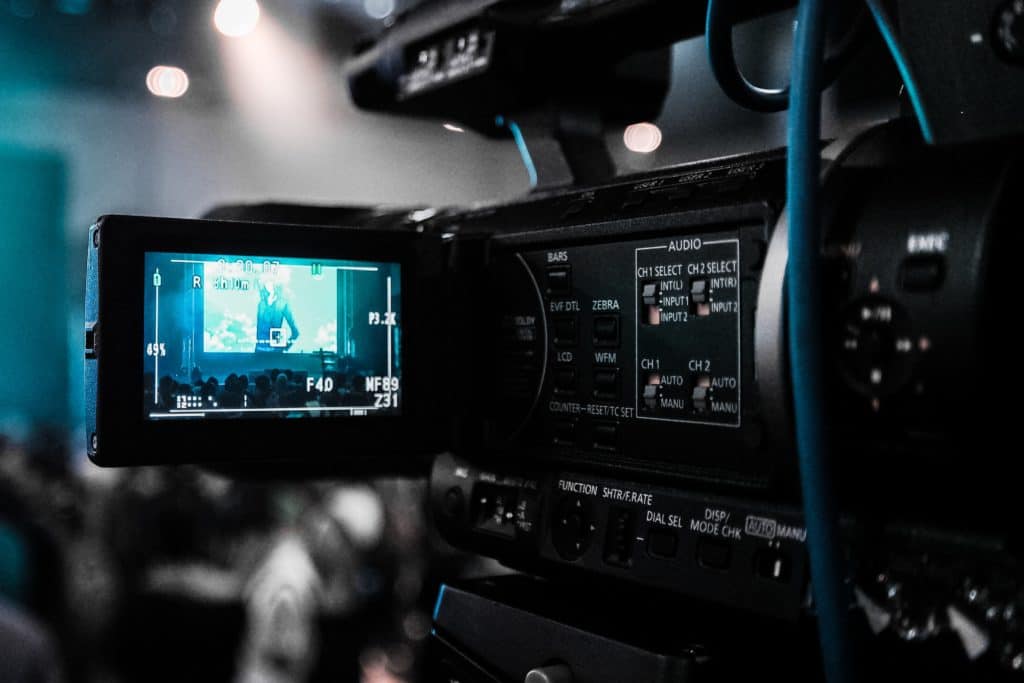 alt="cameraman's view of video subject situated behind the camera and looking at the viewfinder"