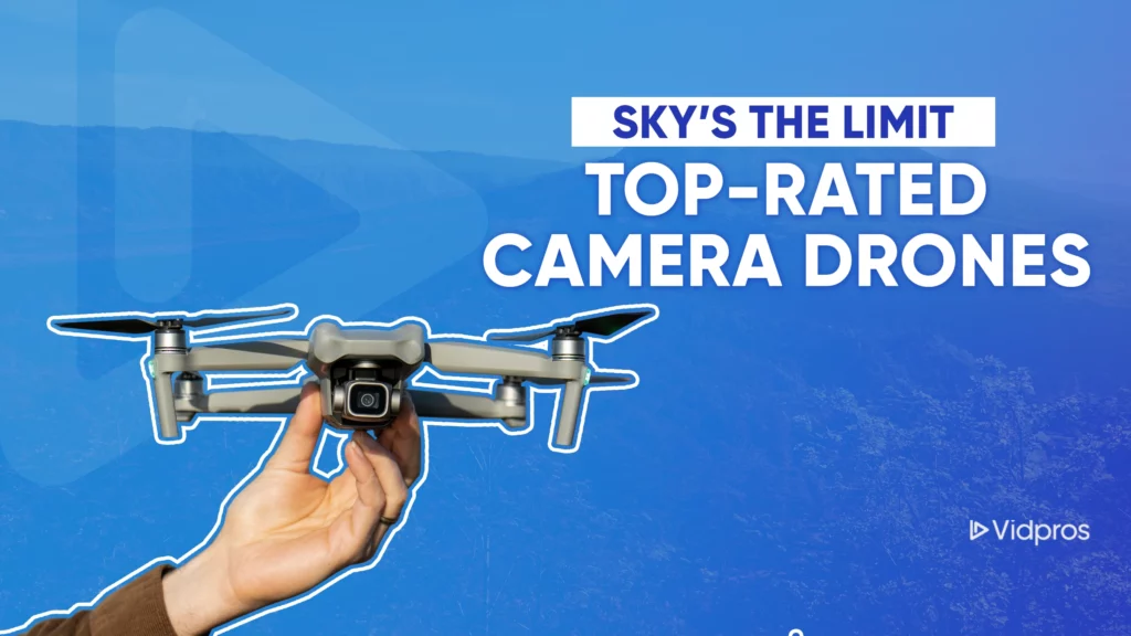 A hand holds a camera drone against a scenic backdrop of distant mountains and trees. The text reads, Skys the Limit: Top-Rated Camera Drones. Highlighting top-rated drones with HD cameras, the Vidpros logo graces the bottom right corner.